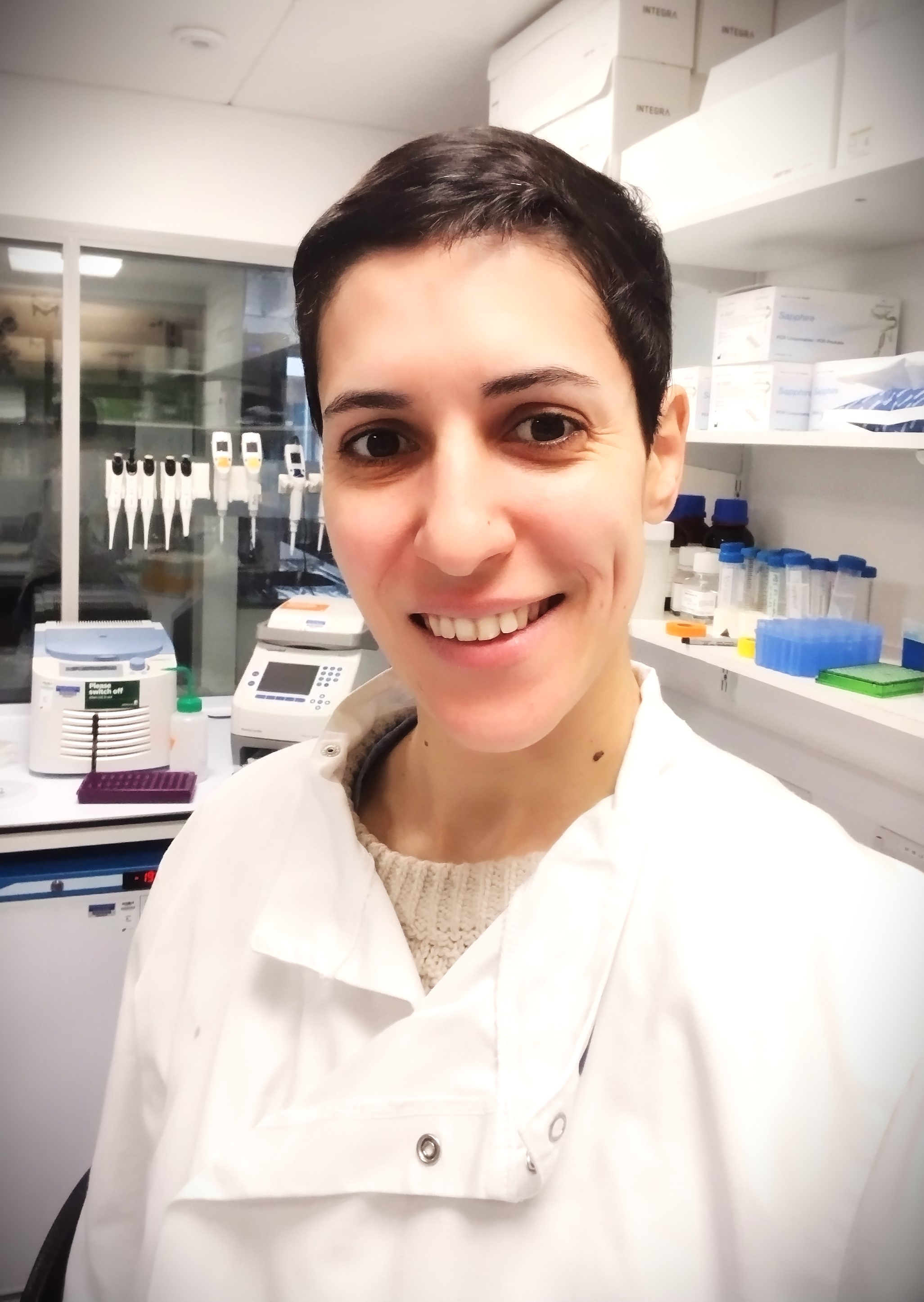 Woman with short hair wearing a lab coat in the lab.